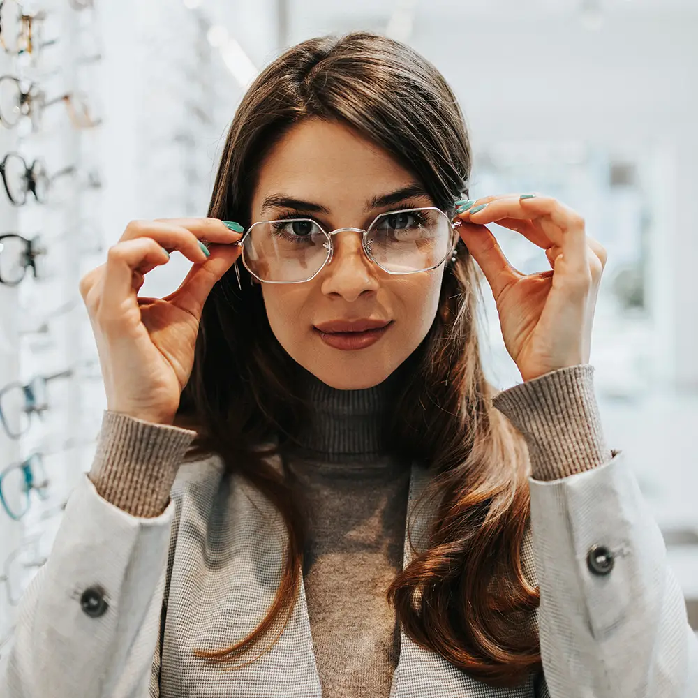 Beautiful-and-fashionable-woman-choosing-eyeglasses-frame-in-modern-optical-store